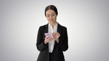 Takım elbiseli sıradan bir kadın telefonuyla grafiksel arka planda mesajlaşıyor..
