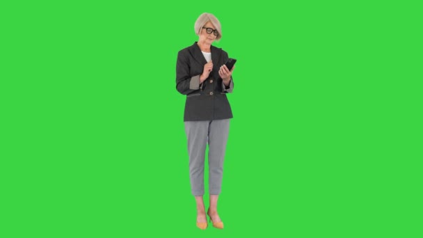 Mujer anciana de negocios trabaja en un teléfono inteligente en una pantalla verde, Chroma Key. — Vídeos de Stock