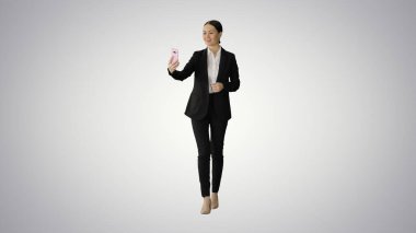 Takım elbiseli genç bir kadın telefonunda iş videosu var.