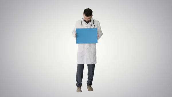 Arab doctor standing showing placard and telling something on gr — Stock fotografie