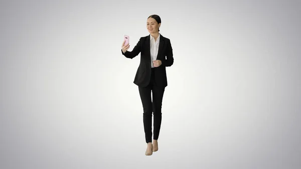 Mujer joven en un traje que tiene videollamada de negocios en su teléfono o — Foto de Stock
