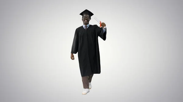 Feliz afroamericano estudiante masculino en la túnica de graduación caminar w — Foto de Stock