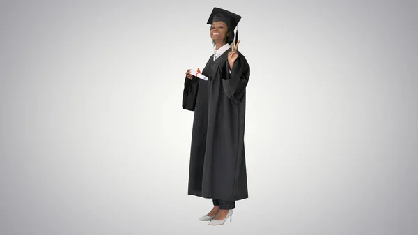 Sorridente studentessa afroamericana in vestaglia di laurea posin — Foto Stock