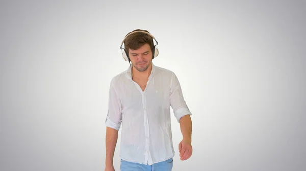 Młody mężczyzna w słuchawkach słuchający muzyki i cieszący się nią wałki — Zdjęcie stockowe