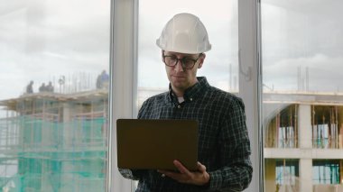 Yakışıklı erkek mühendis iş için bir defter kullanıyor..