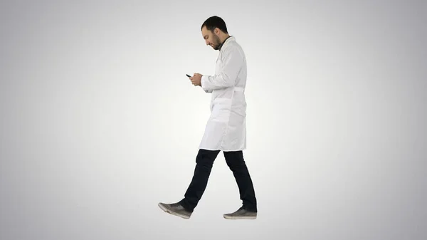 Camminare medico professionista utilizzando lo smart phone e rendendo assistente — Foto Stock