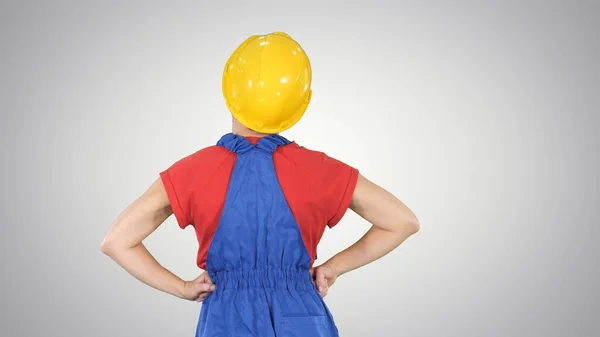 Female construction worker with hands on hips looking at somethi