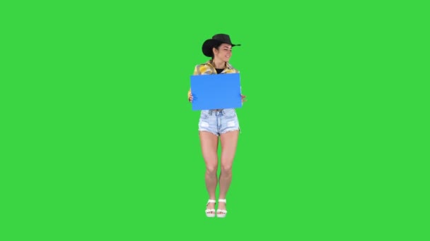 Leende söt cowgirl hålla tom styrelse och dansa på en grön skärm, Chroma Key. — Stockvideo