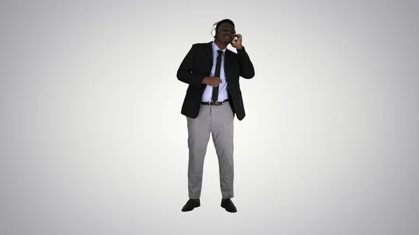 Black businessman dancing to music in headphones on gradient bac — Stock Photo, Image