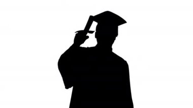 Siluet. Mezuniyet cüppeli mutlu Afrikalı Amerikalı erkek öğrenci diplomasını sallayarak kameraya doğru yürüyor..