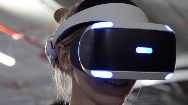 Beyaz kadın VR kulaklık takıyor ve gülümsüyor..