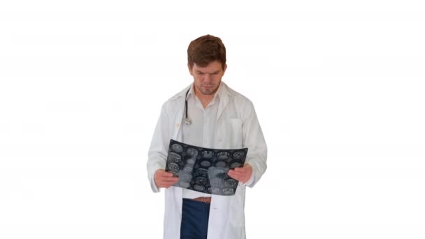 Концентрированный врач-мужчина, изучающий компьютерную томографию во время ходьбы на белом фоне. — стоковое видео