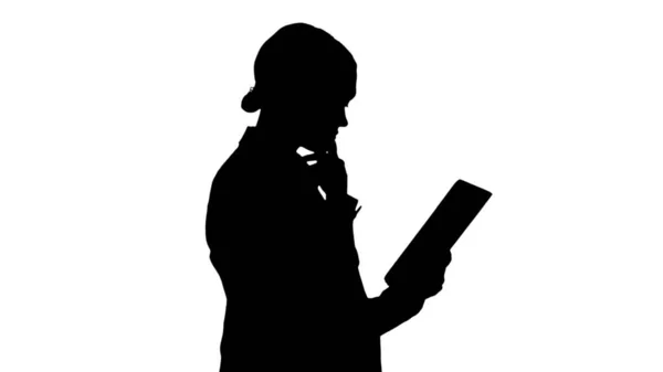 Silhouette Businesswoman usando una tableta mientras camina. — Foto de Stock
