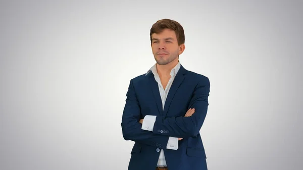 Handsome young businessman standing arms crossed, smiling confid