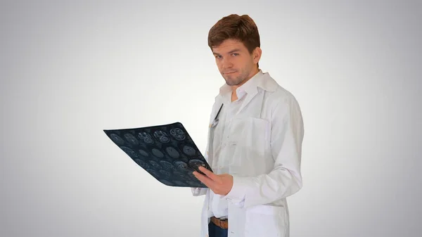 Mężczyzna lekarz sprawdzanie tomografii komputerowej i patrząc w aparat a — Zdjęcie stockowe