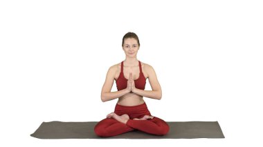 Yogada oturan genç ve güzel bir kadın Lotus pozunu değiştiriyor.