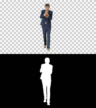 Takım elbiseli genç adam yürürken trompet çalıyor, Alpha Channel.