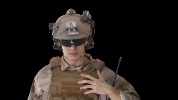 Young soldier walks, holds a radio station and gives orders, Alpha Channel — Stock Video