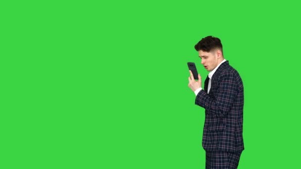 Een jonge zakenman danst nadat hij ruzie had aan de telefoon op een groen scherm, Chroma Key. — Stockvideo