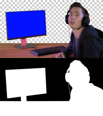 Oyuncu, PC Monitörü Alpha Channe 'nin yanında oturan kamerayla konuşuyor.