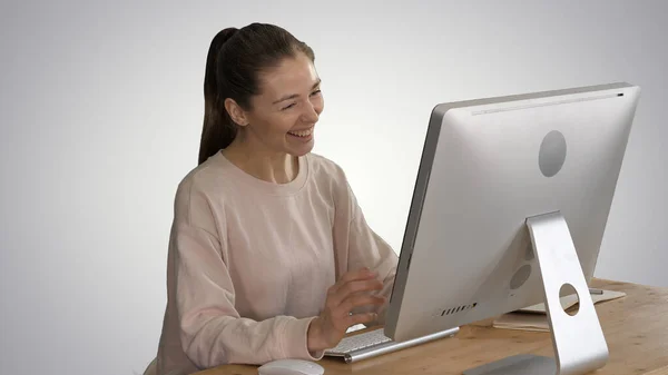 Счастливая женщина с видеозвонком сидит перед своим компьютером — стоковое фото