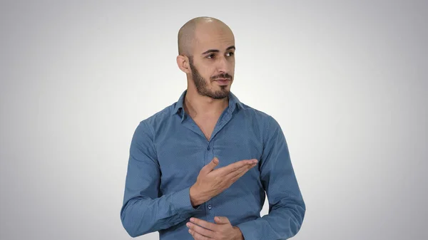 Arabski młody człowiek w koszuli mówi coś prezentując i punkt — Zdjęcie stockowe