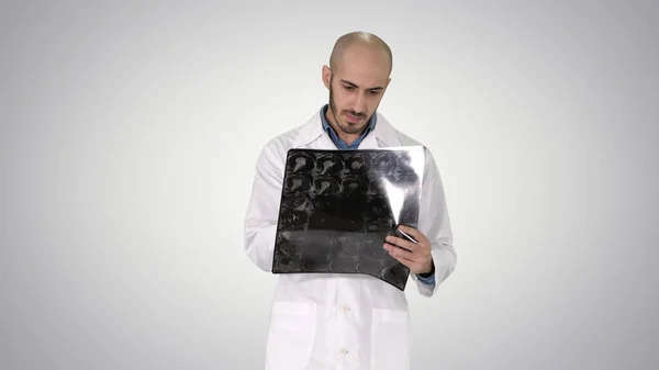 Médico que revê a radiografia do ombro enquanto caminha no gradiente b — Fotografia de Stock