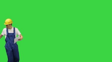 Üç genç inşaat işçisi yeşil ekran, Chroma Key 'de aptalca bir yürüyüş yaparken belgeleri teslim ediyorlar..