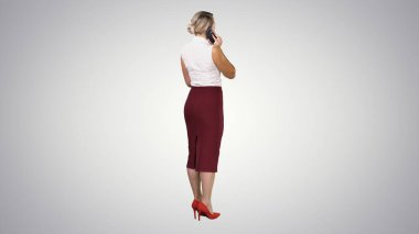 Standing young beautiful woman using a mobile phone making a cal clipart