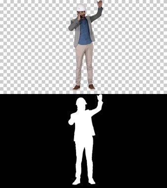 Mühendis, cep telefonuyla konuşuyor. İnşaat çalışmalarını inceliyor.