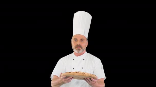 Atrakcyjny kucharz z pizzą w ręku spacerujący i rozmawiający z kamerą, Alpha Channel — Wideo stockowe