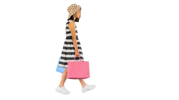 穿着白色背景的购物袋走路的小女孩很可爱. — 图库照片