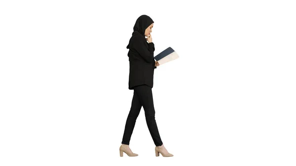 Мусульманская предпринимательница читает своего бизнес-планировщика во время прогулки — стоковое фото