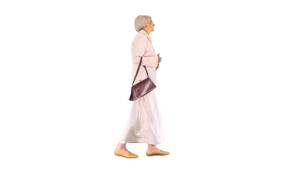 Приваблива розумна старша жінка, що йде на білому тлі . — стокове фото