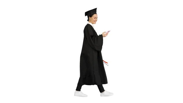 Sorrindo mulher graduada em texto de argamassa em seu telefone enquanto — Fotografia de Stock