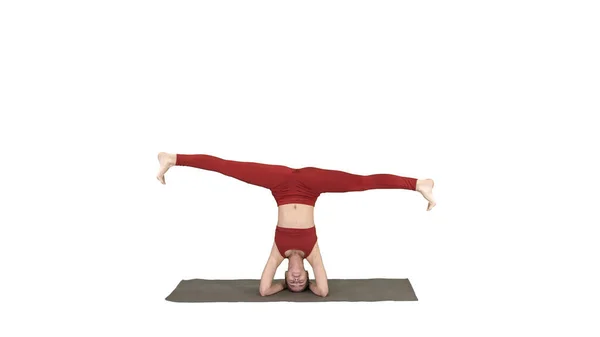 Mulher realizando um headstand com divisão no fundo branco. — Fotografia de Stock