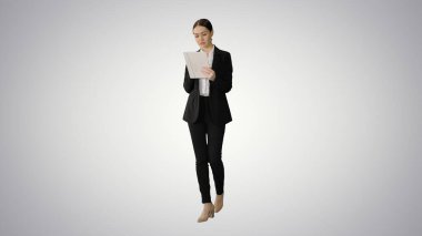 İş kadını gradyan sırt üstü yürürken tablet kullanıyor