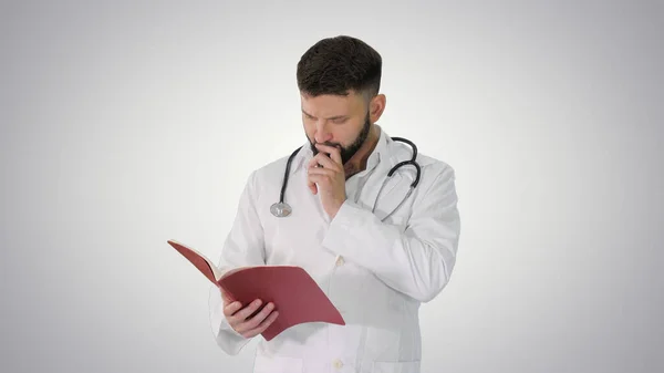 Doctor reading a book or a journal while walking on gradient bac — Stock Photo, Image