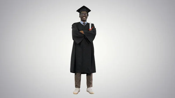 Afrikaans amerikaans man student in graduation robe vouwen armen wi — Stockfoto
