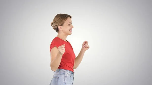 Mujer joven en camiseta roja, jeans bailando y caminando en gradien — Foto de Stock