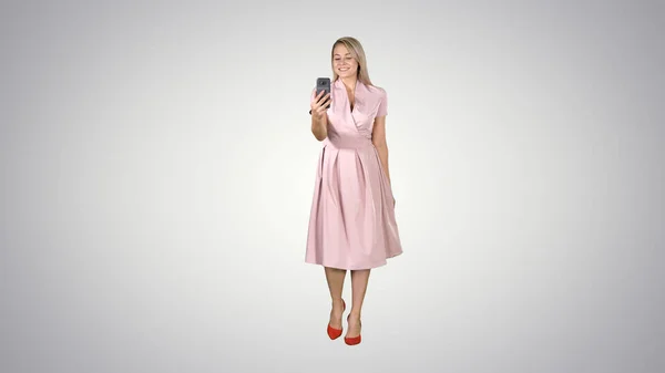 Blondynka w różowych ubraniach robi selfie i chodzi po stopniach — Zdjęcie stockowe