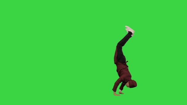 Mannelijke chef-kok in rood uniform doen salto 's en hand spins kijken naar de camera op een groen scherm, Chroma Key. — Stockvideo