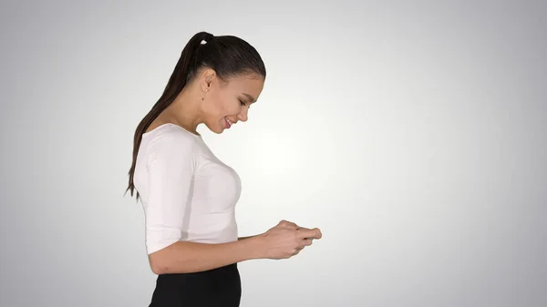 Zakelijke vrouw met smartphone en lopen op gradiënt backgrou — Stockfoto