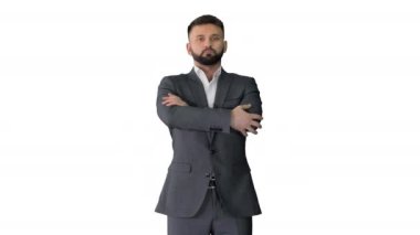 Sakallı ve bıyıklı kendine güvenen bir iş adamı beyaz arka planda elleri bağlı duruyor..
