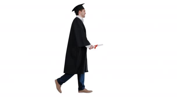 Feliz estudiante masculino en bata de graduación caminando y besando su diploma sobre fondo blanco. — Vídeos de Stock