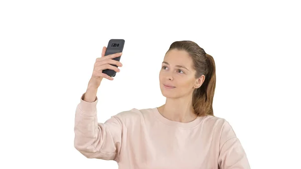 Sorrindo jovem mulher tomando uma selfie sorrindo no fundo branco. — Fotografia de Stock