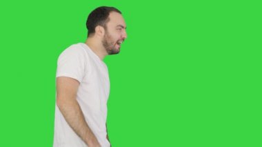 Uykulu, beyaz tişörtlü, yeşil ekranda yürürken gözlerini ovuşturan adam, Chroma Key..