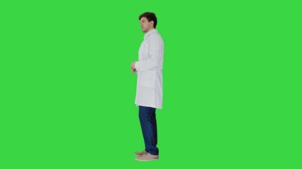 Az orvos fehér köpenyt visel, ami megmagyaráz valamit a zöld képernyőn, Chroma Key. — Stock videók