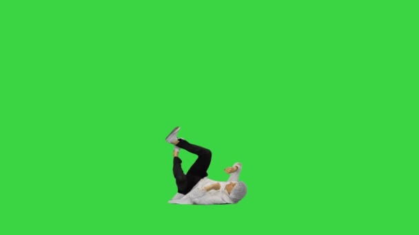 Dokter muda berjubah putih dan topi pelindung melakukan breakdance backspin dan melihat kamera di akhir layar hijau, Chroma Key. — Stok Video