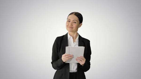 Mujer de negocios sonriente usando la almohadilla de la computadora mientras camina hacia t —  Fotos de Stock